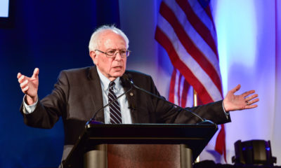 Picture of Sen. Bernie Sanders speaking with American flag in the background