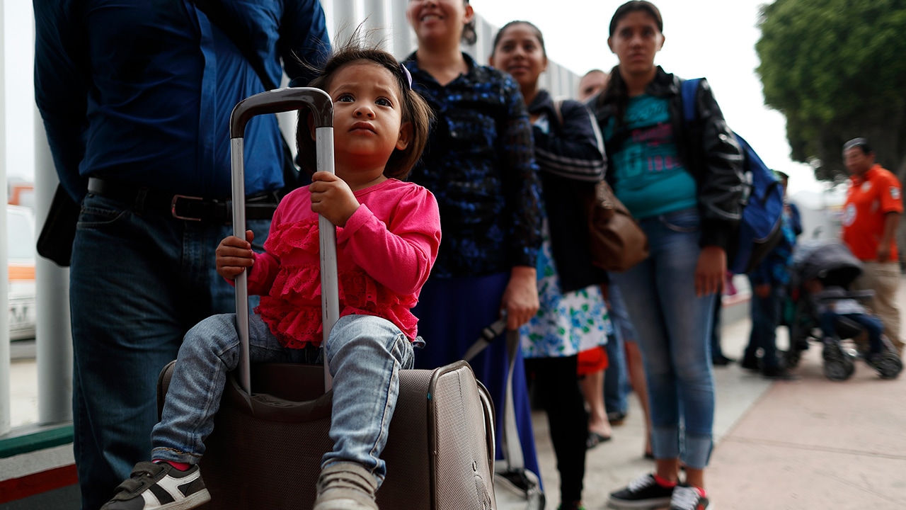 Photo of people waiting to cross into the U.S. to begin the process of applying for asylum