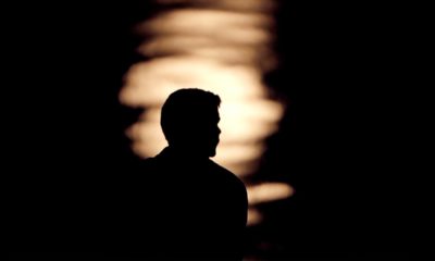 Photo of a man is silhouetted against moonlight reflecting off the Missouri River