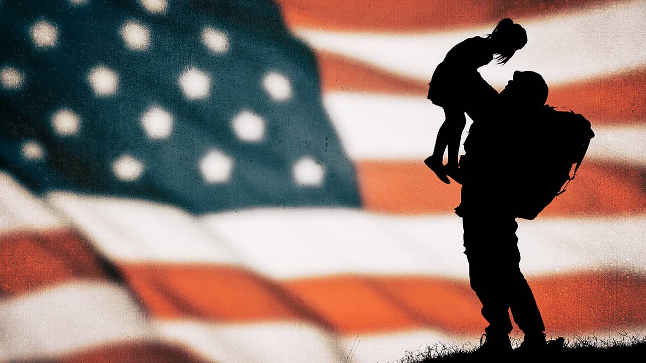 Photo of an American flag with a soldier and child silhouette