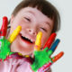 Photo of young girl with down syndrome showing off her painted hands