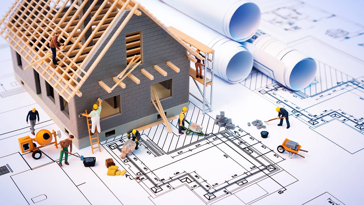 Photo of miniature house and blueprints.