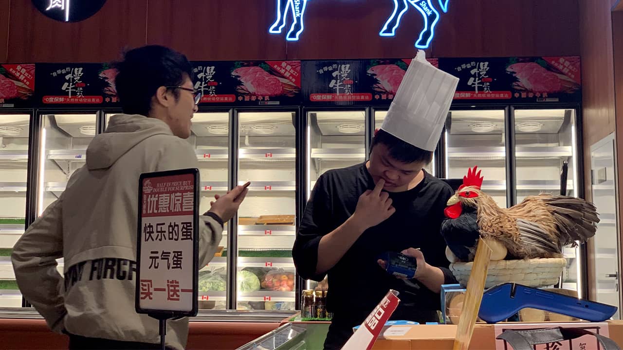 Photo of worker at the imported beef section of a supermarket