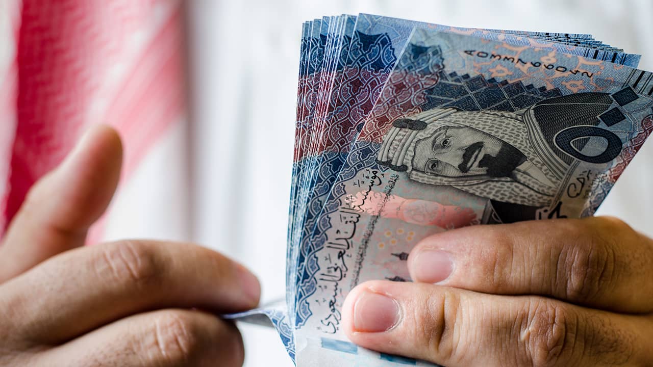 Photo of a man counting Saudi money