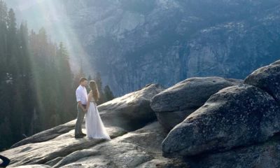 Photo of a couple at Yosemite's Glacier Point bathed in a ray of sunlight