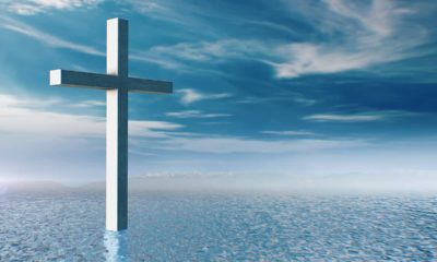 Composite illustration of a cross, blue water, and blue sky with cloudsPhot