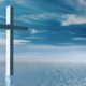 Composite illustration of a cross, blue water, and blue sky with cloudsPhot