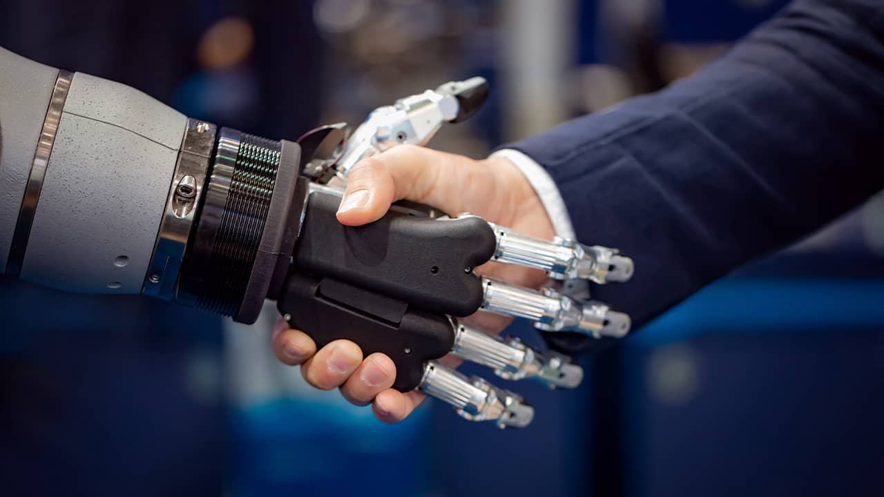 Photo of a robot shaking hands with a businessman