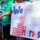 Photo of students holding a homemade sign saluting their heroes