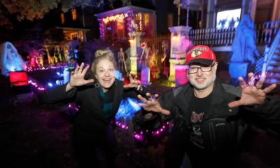 Photo of Beth LeFauve and Nelson Gonzalez posing in front of their decorated homes