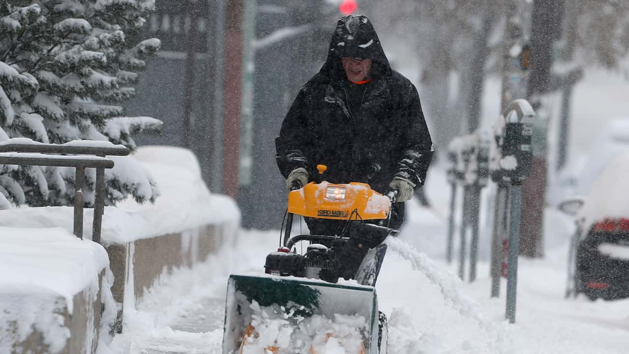 Photo of a man using a snowblower