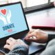 Photo of a woman at a laptop donating online