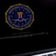 Photo of a laptop with a Department of Justice logo on the screens