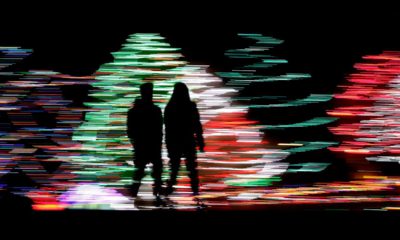 Photo of people against a Christmas lights display