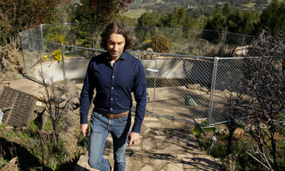 Photo of Jason Meeks walking through the remains of his hime in Santa Rosa, Calif.