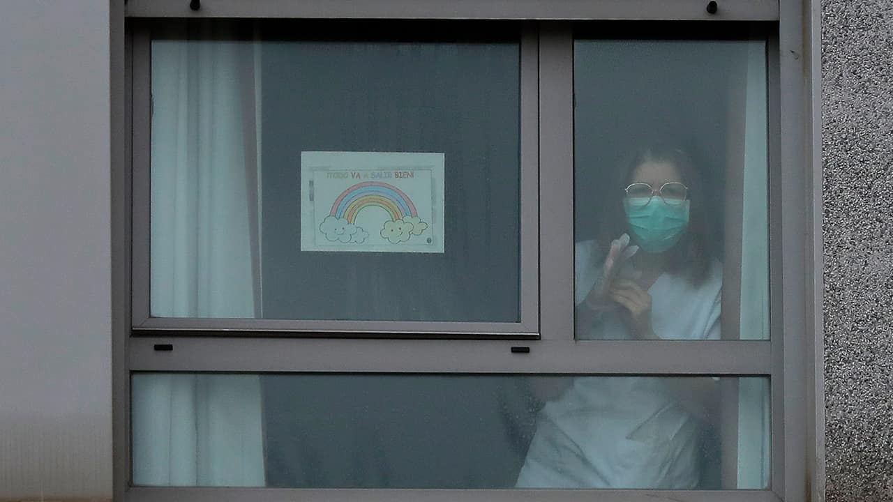 Photo of a nurse looking out the window of a nursing home