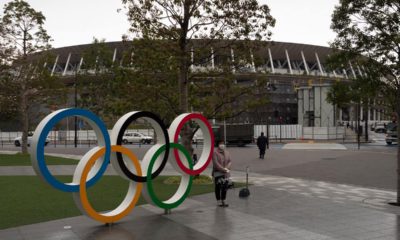 Photo of a woman posing by the Olympics rings in Tokyo