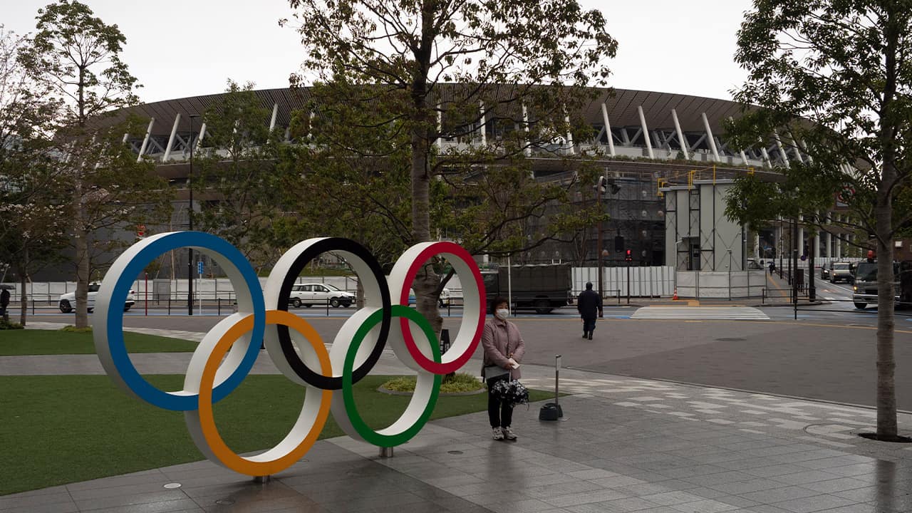 Photo of a woman posing by the Olympics rings in Tokyo