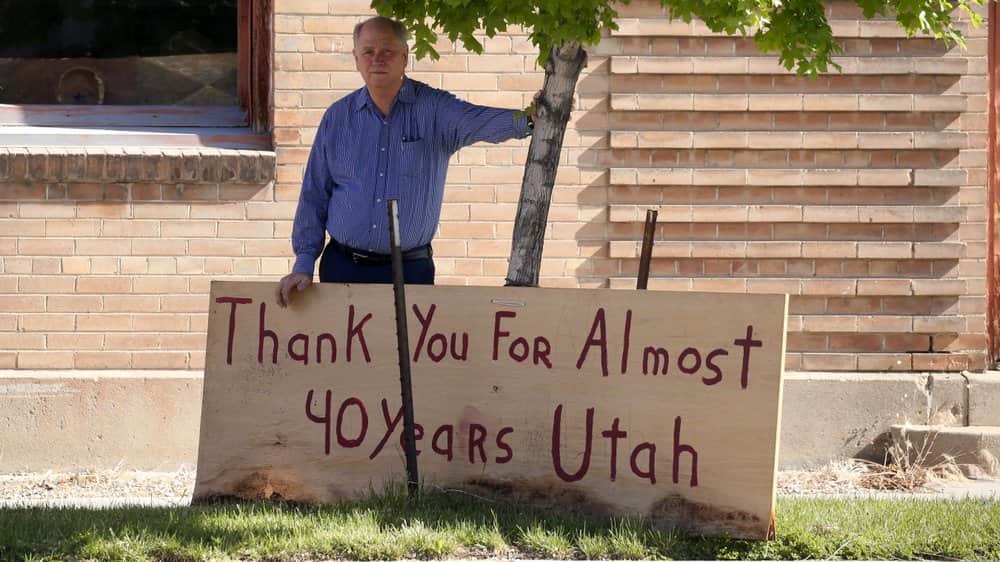 Photo of Scott Evans posing with a sign