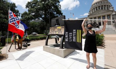 Photo of a woman holding a Black Lives Matter flag