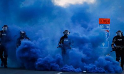 Photo of police officers in blue smoke