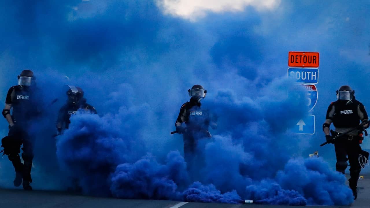 Photo of police officers in blue smoke