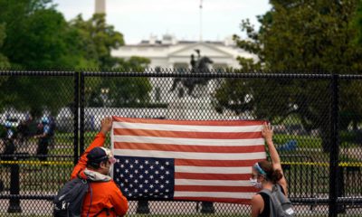 Photo of people holding a flag upside down at the white house